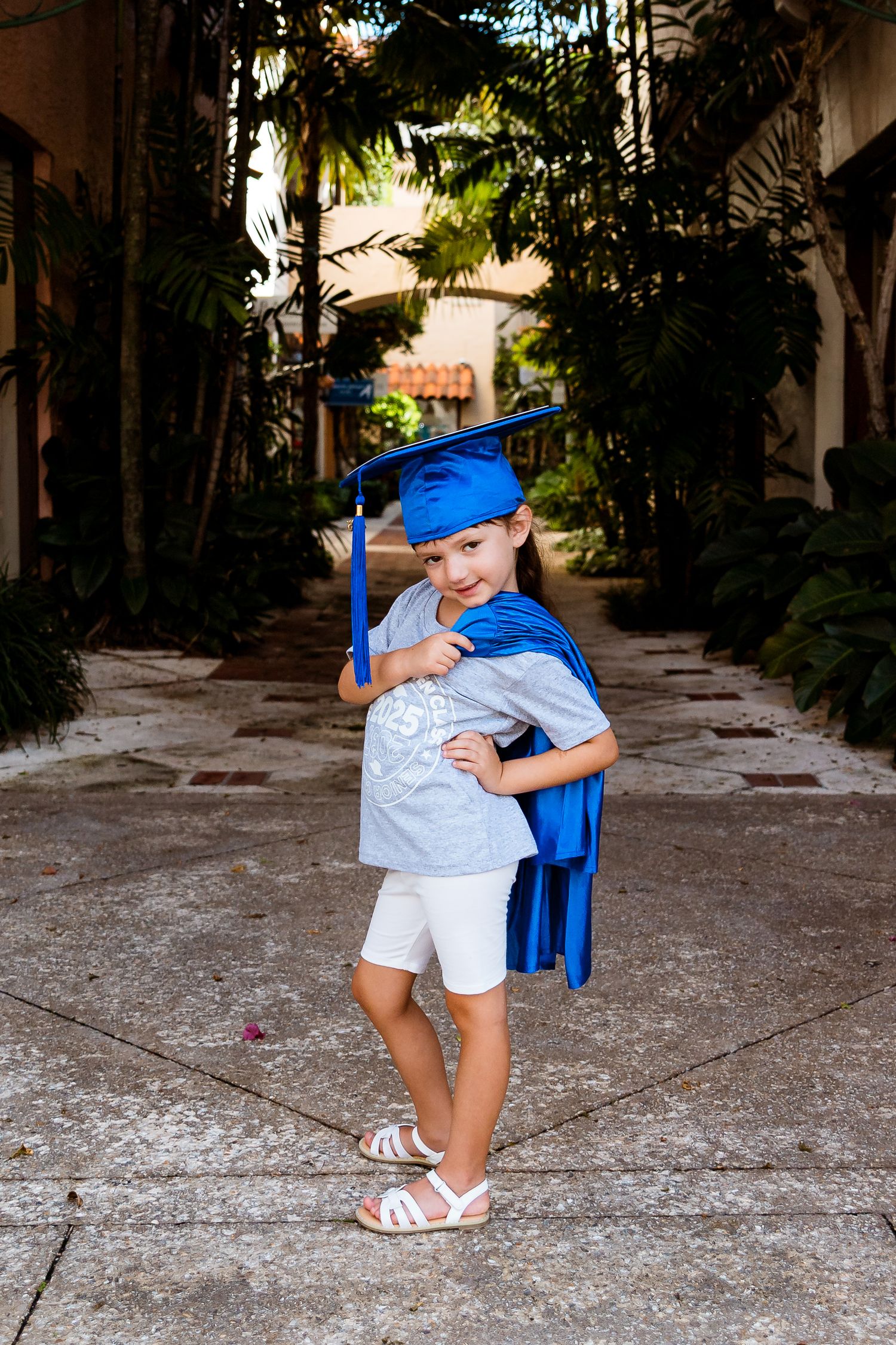 A sequence of five images shows a young child in blue cape looking back while walking down a palm tree-lined path.