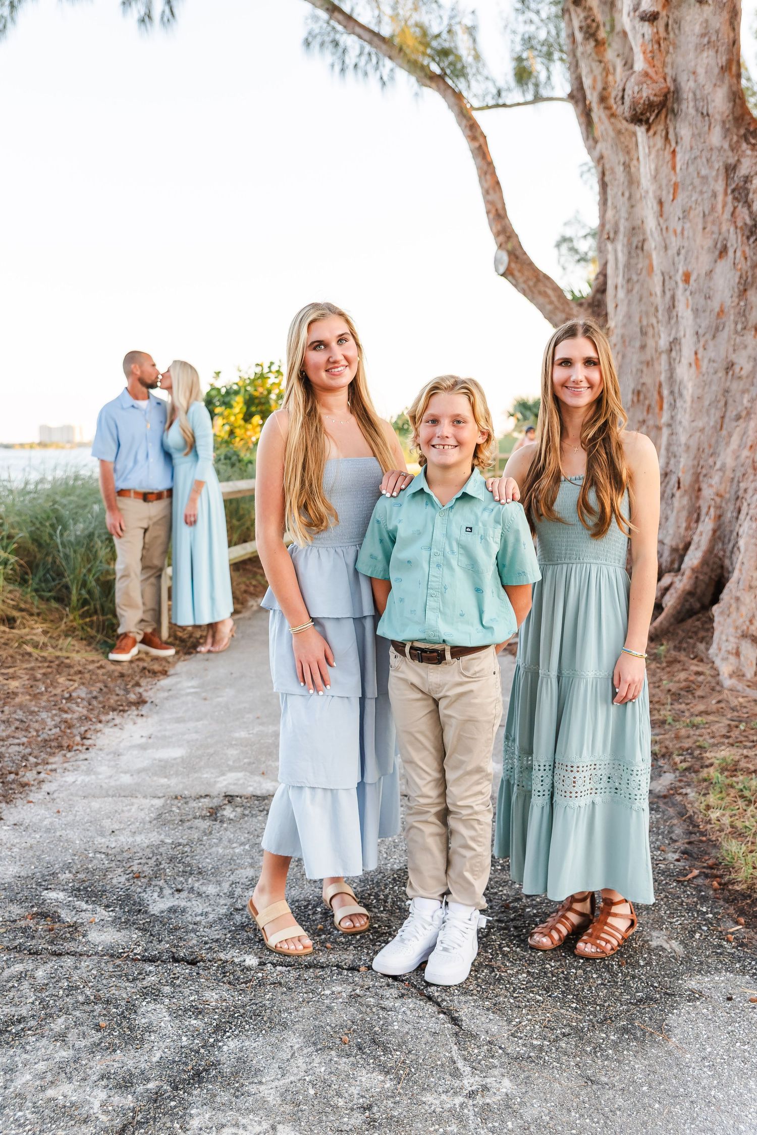 Casual family photos taken at beach location with coordinating mint and blue outfits.