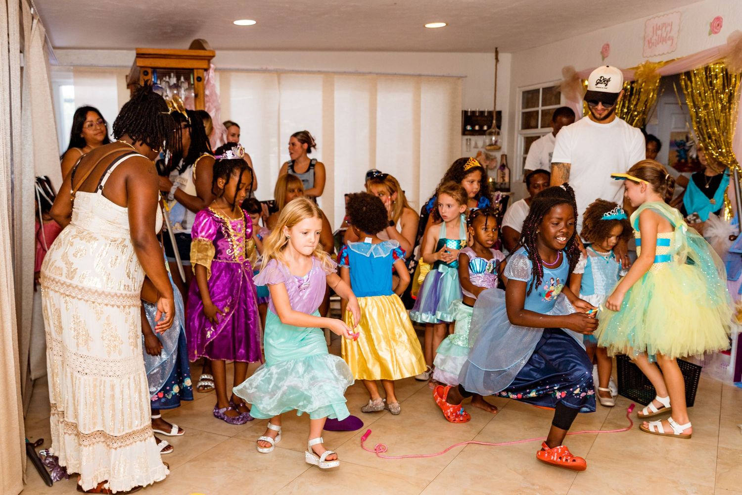 A panoramic view of a children's dance party or recital with young dancers in colorful tutus and dresses.