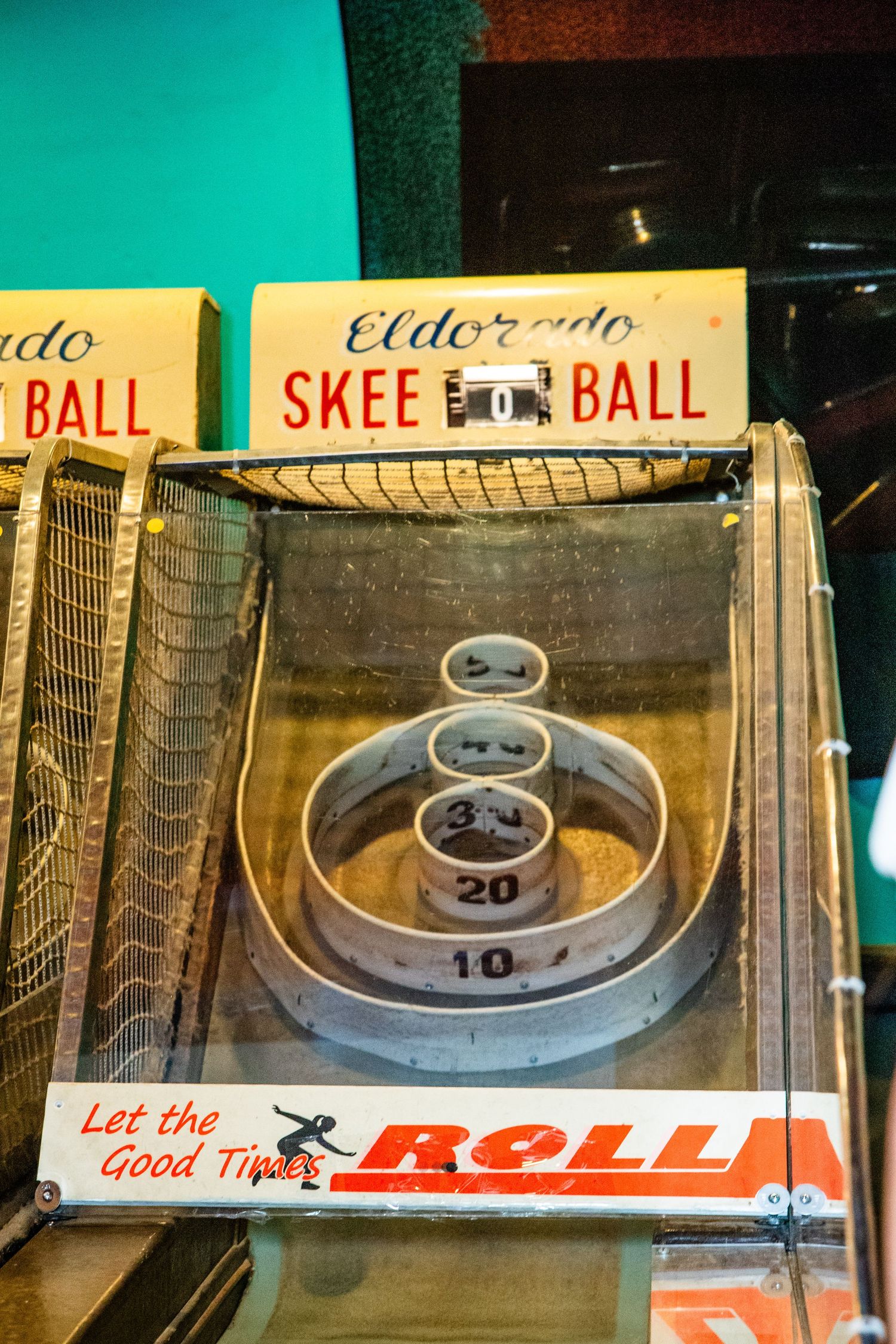 An arcade game machine displaying a 'Skee Ball' game, with a ramp and multiple scoring targets.