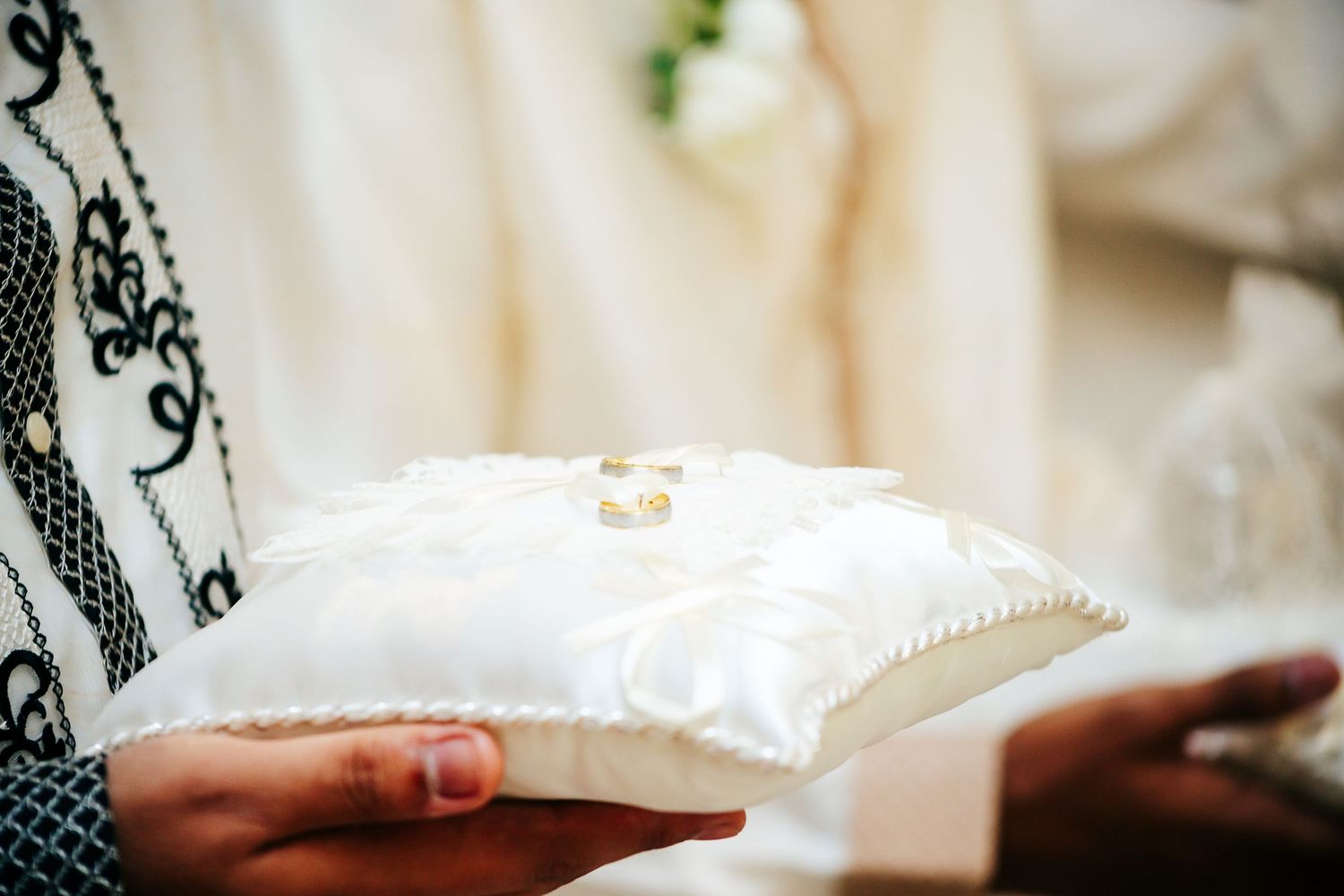 Close-up detail of delicate white lace fabric and intricate beading.