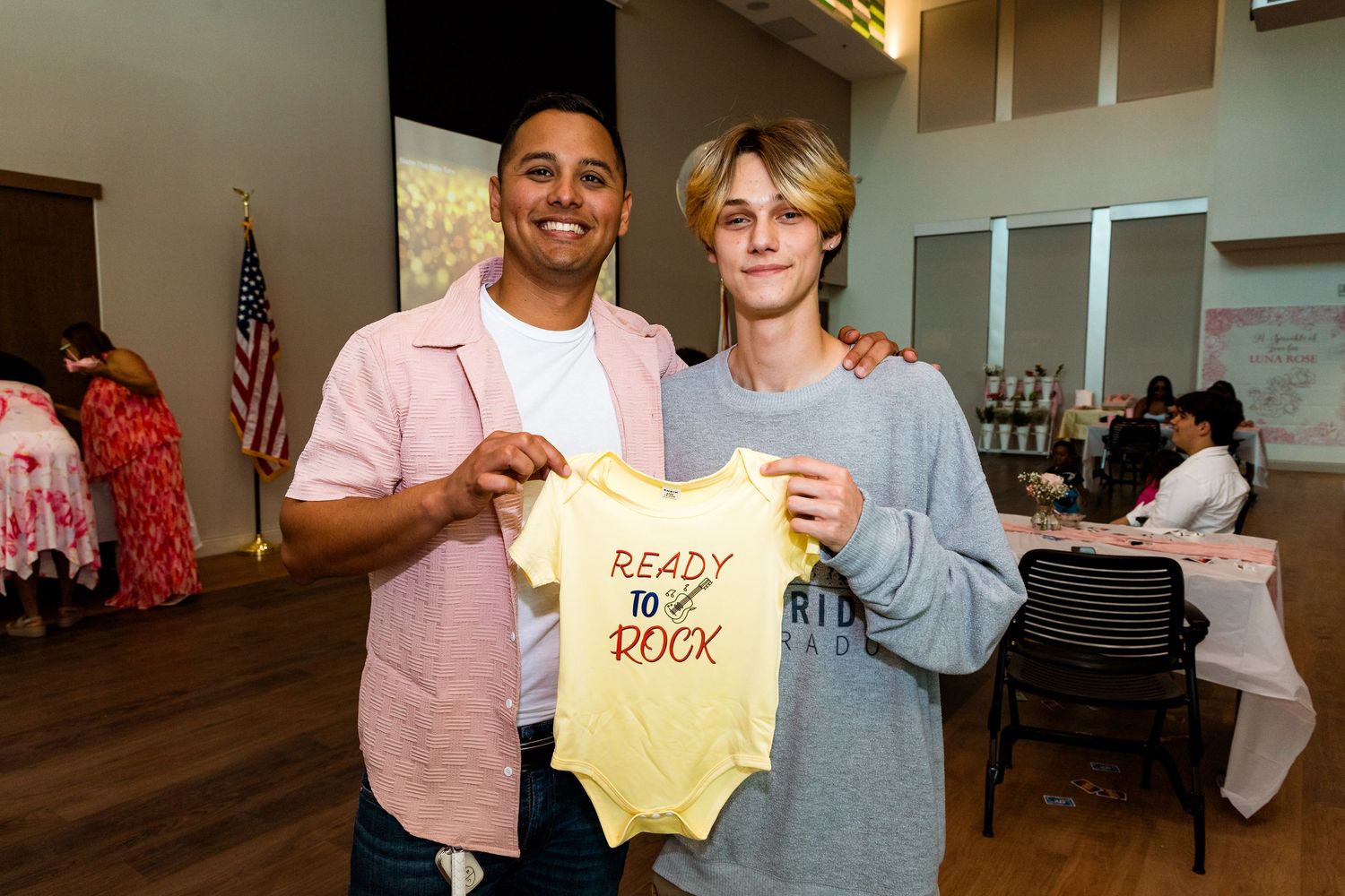 Baby shower decorations and gifts displayed with 'Ready to Pop' onesie theme.