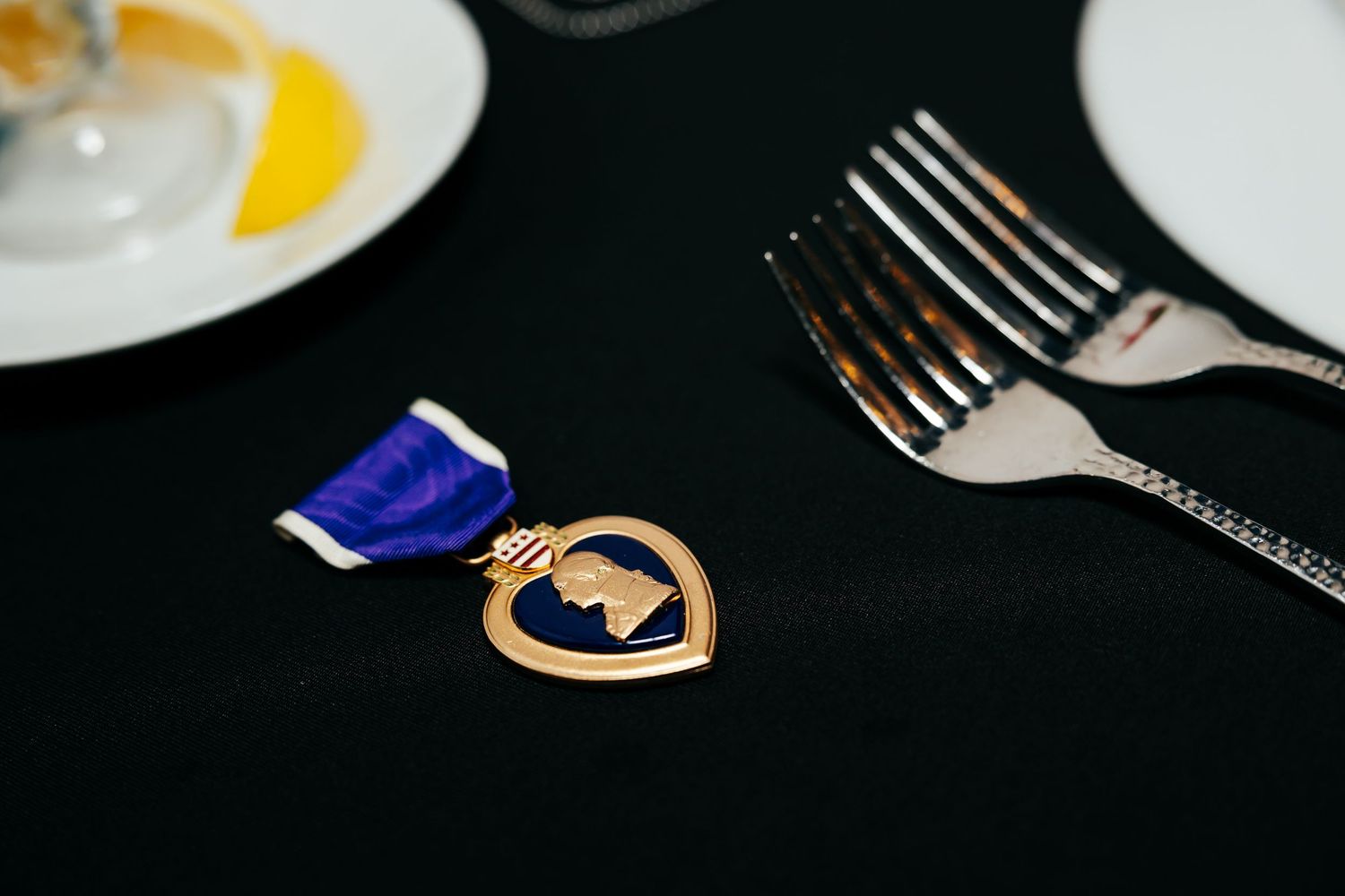 Place settings with formal dinnerware and blue napkins at elegant banquet table.