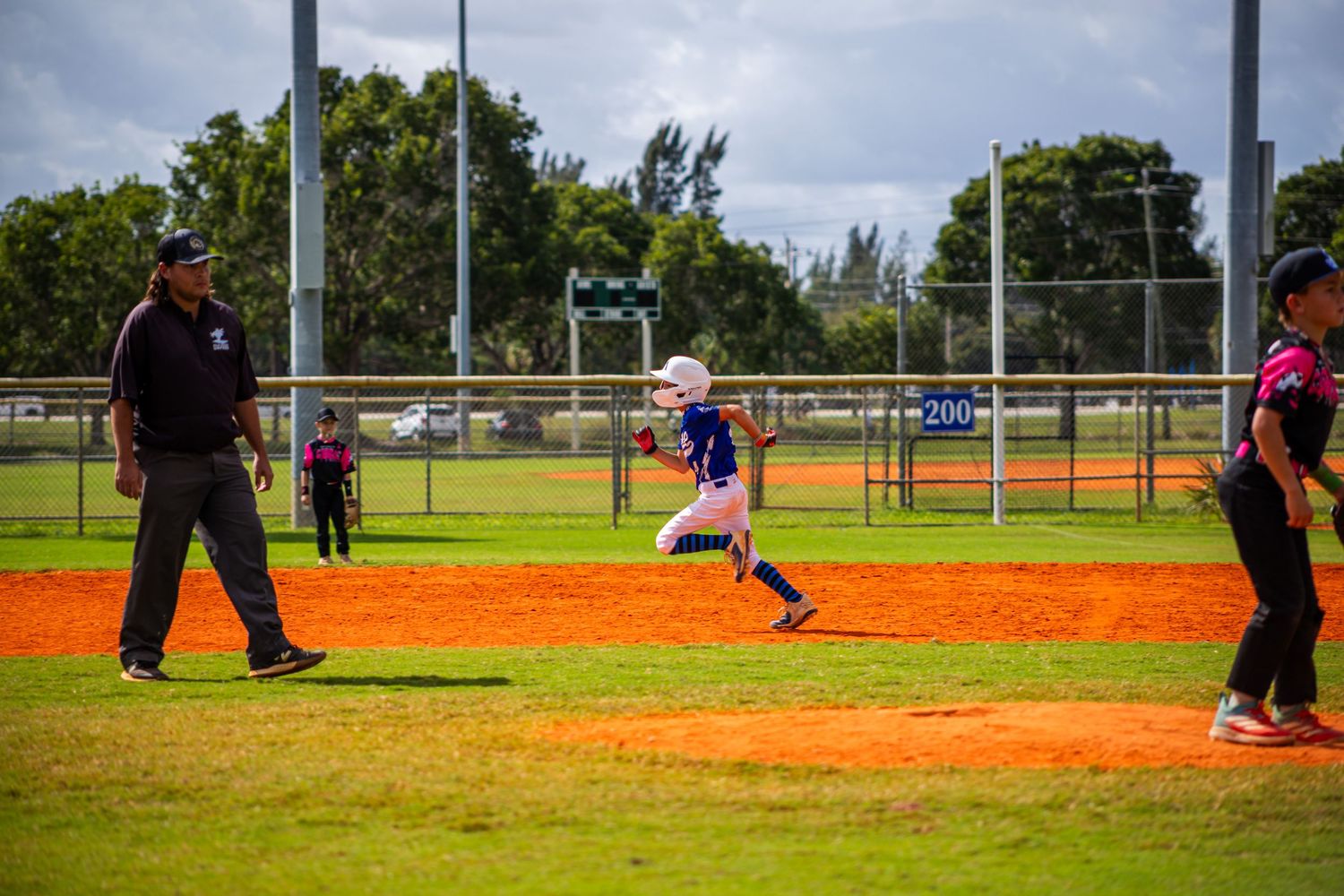 Baseball player leaping horizontally through the air to make a diving catch on a baseball diamond.