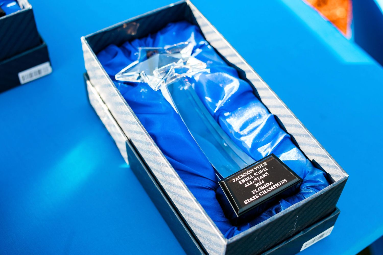 Crystal trophy displayed in protective blue box packaging.