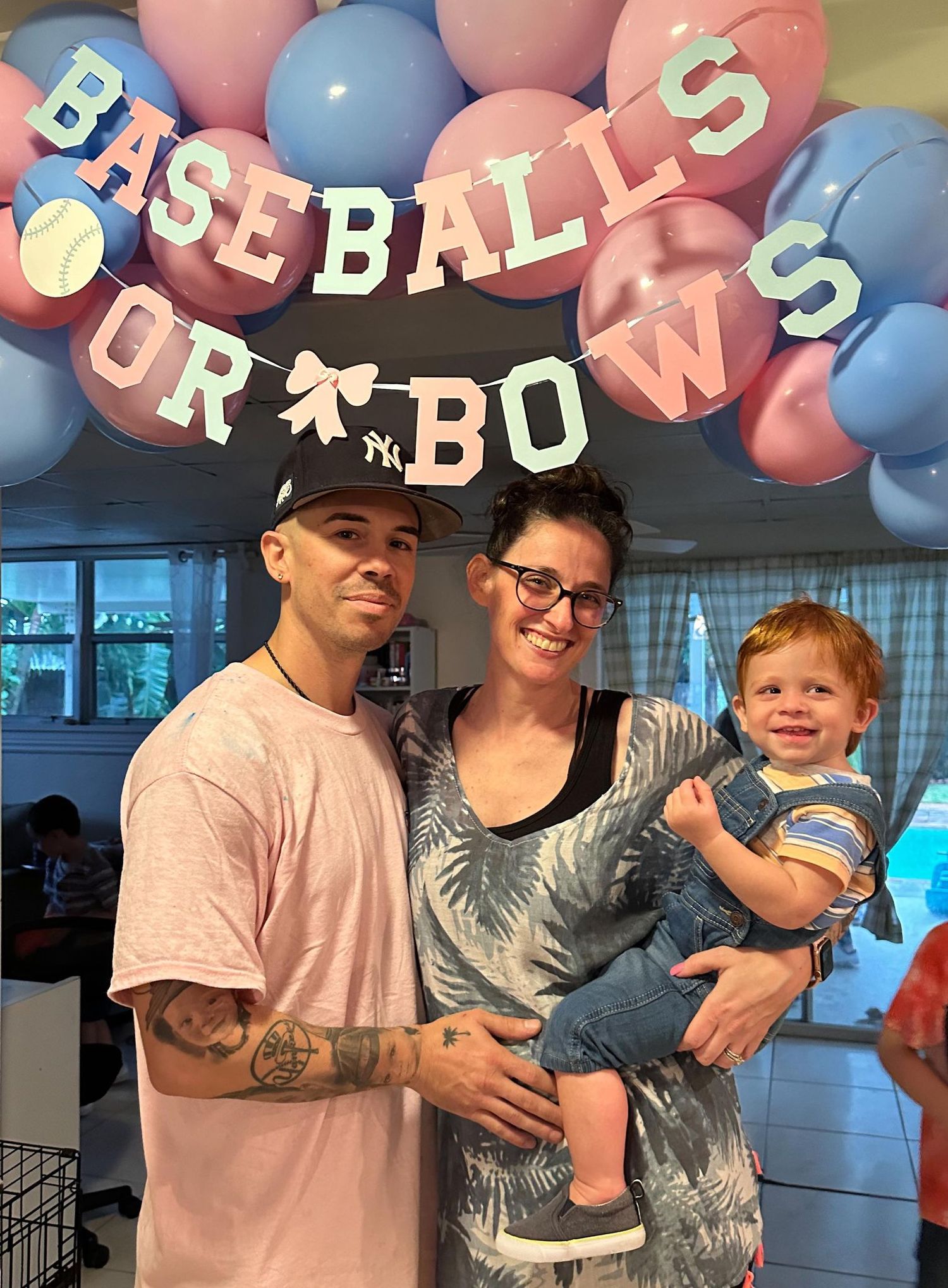 Gender reveal party decoration with blue and pink balloons spelling out 'Baseball or Bows'.