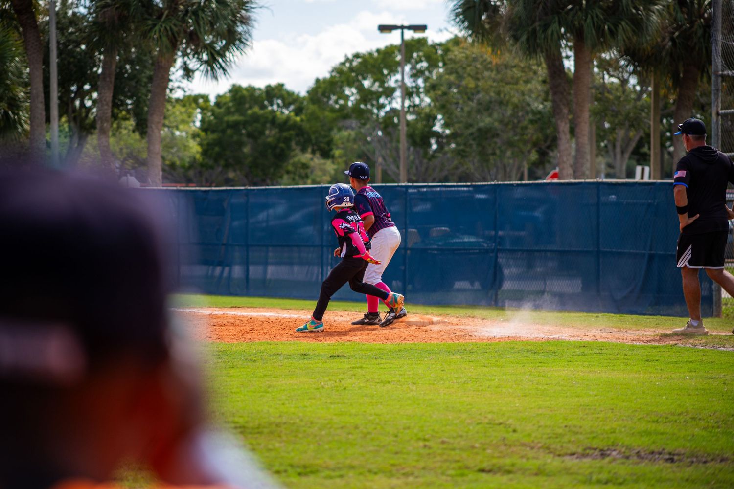 Baseball game action sequence showing players sliding and fielding on a sunny afternoon.
