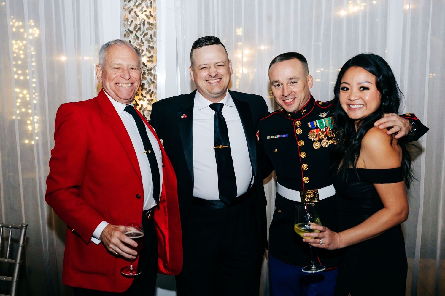 Group photo of attendees in formal wear and military uniforms at an evening reception.
