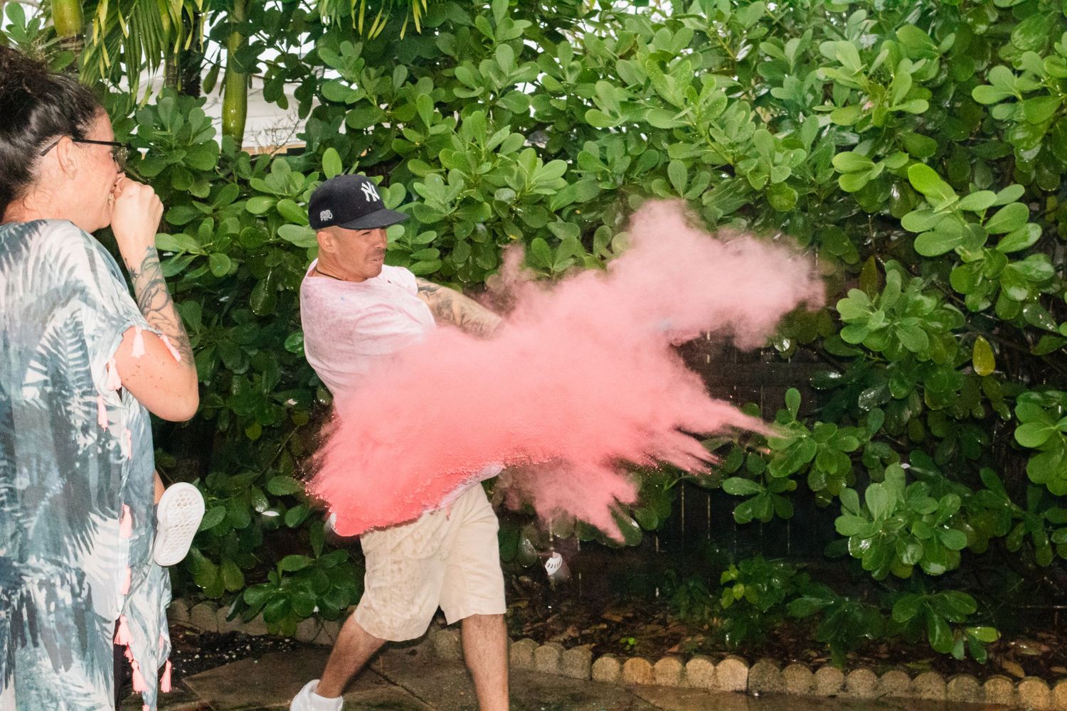 Pink smoke bomb explosion during outdoor gender reveal celebration.