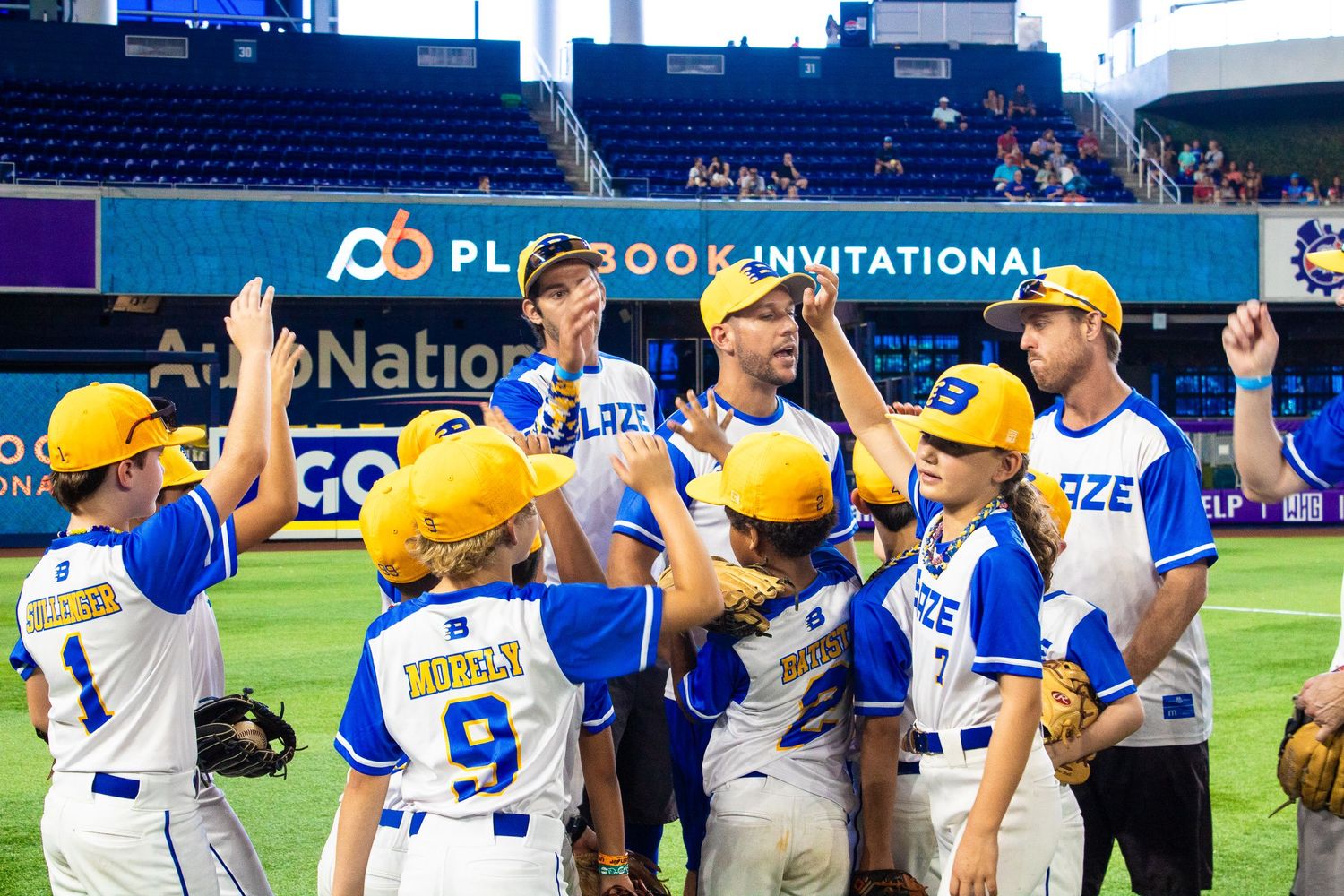Baseball players high-five and celebrate during Playbook Invitational tournament.