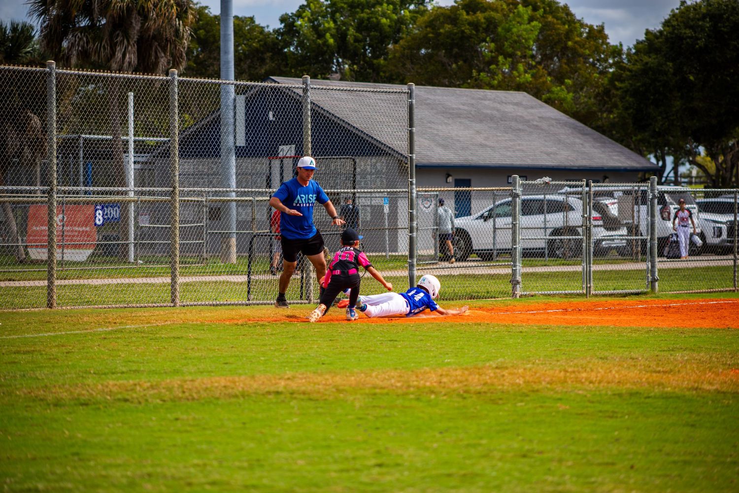 Baseball game action shot on a cloudy day showing players on the field during competitive play.
