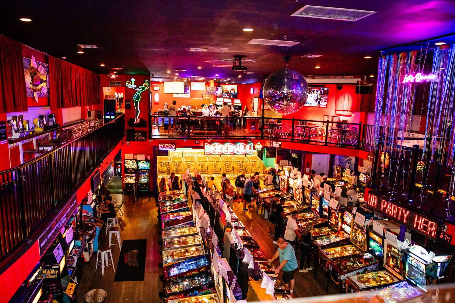 A vibrant and lively interior of a music venue or bar, featuring colorful lighting, musical instruments, and a crowded atmosphere.