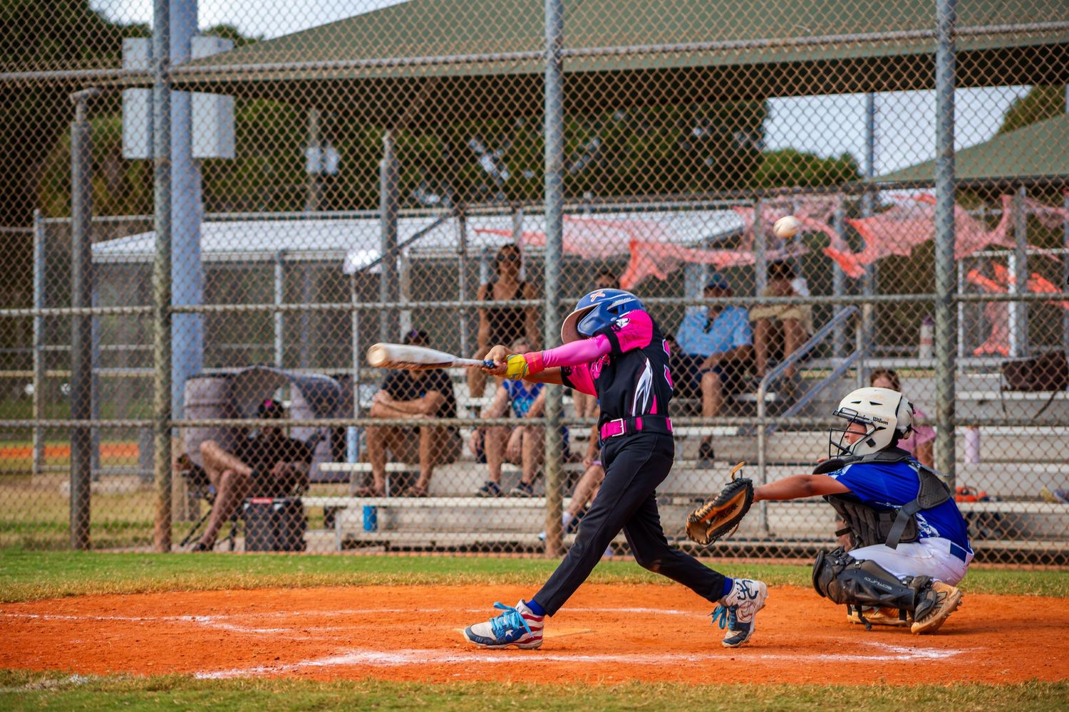 Baseball player sliding into home plate while catcher attempts to make the tag during an intense play at the plate.