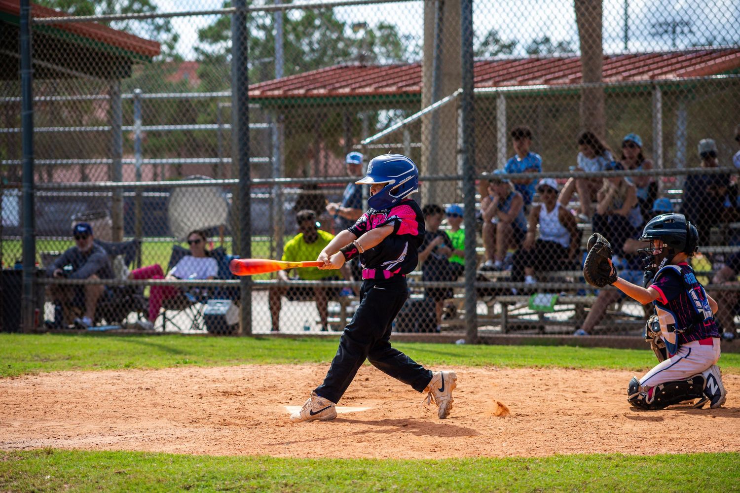 Baseball players engaged in dynamic gameplay with sliding and defensive positioning on the field.