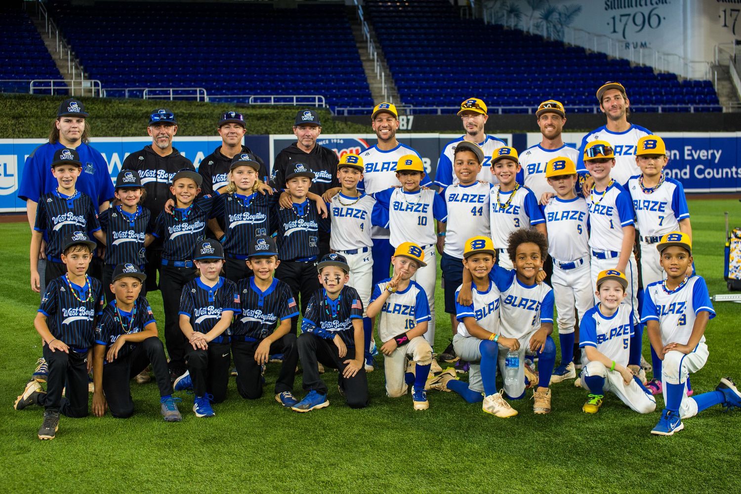 Youth baseball teams gather for group photo on stadium field during Playbook Invitational event.