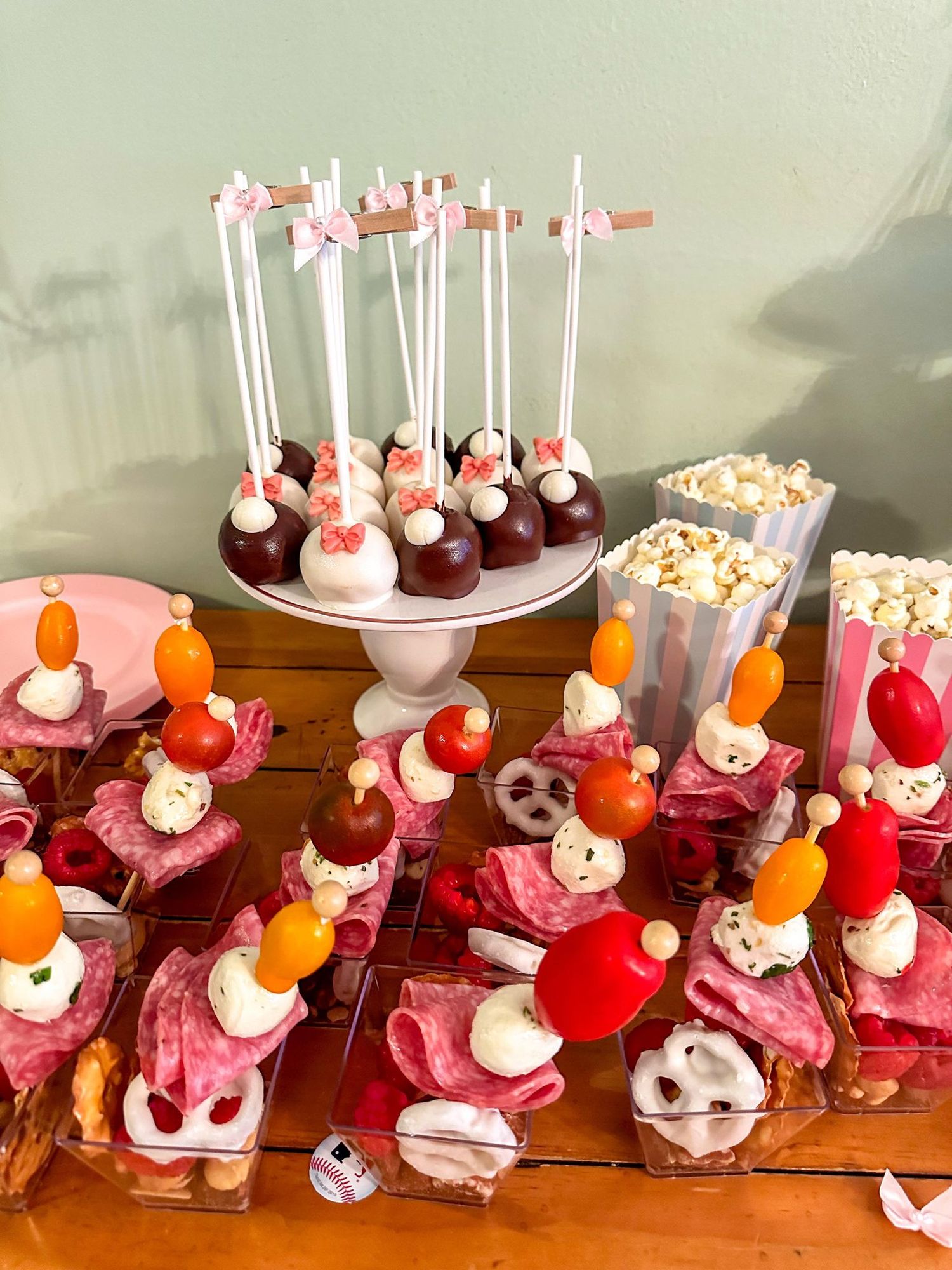 Elegant display of chocolate cake pops and colorful desserts arranged on tiered stands.