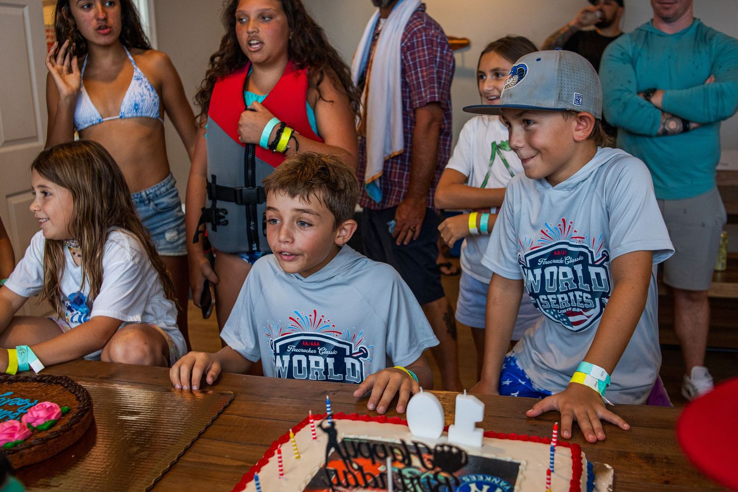 People wearing matching light blue t-shirts gathered around tables at an indoor event.