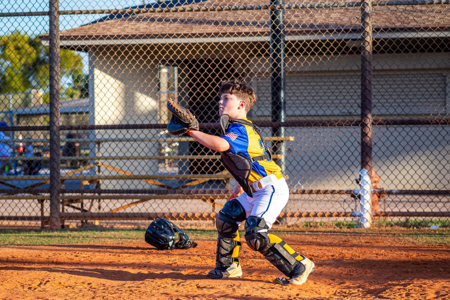 Baseball player sliding into base during game on dirt infield.