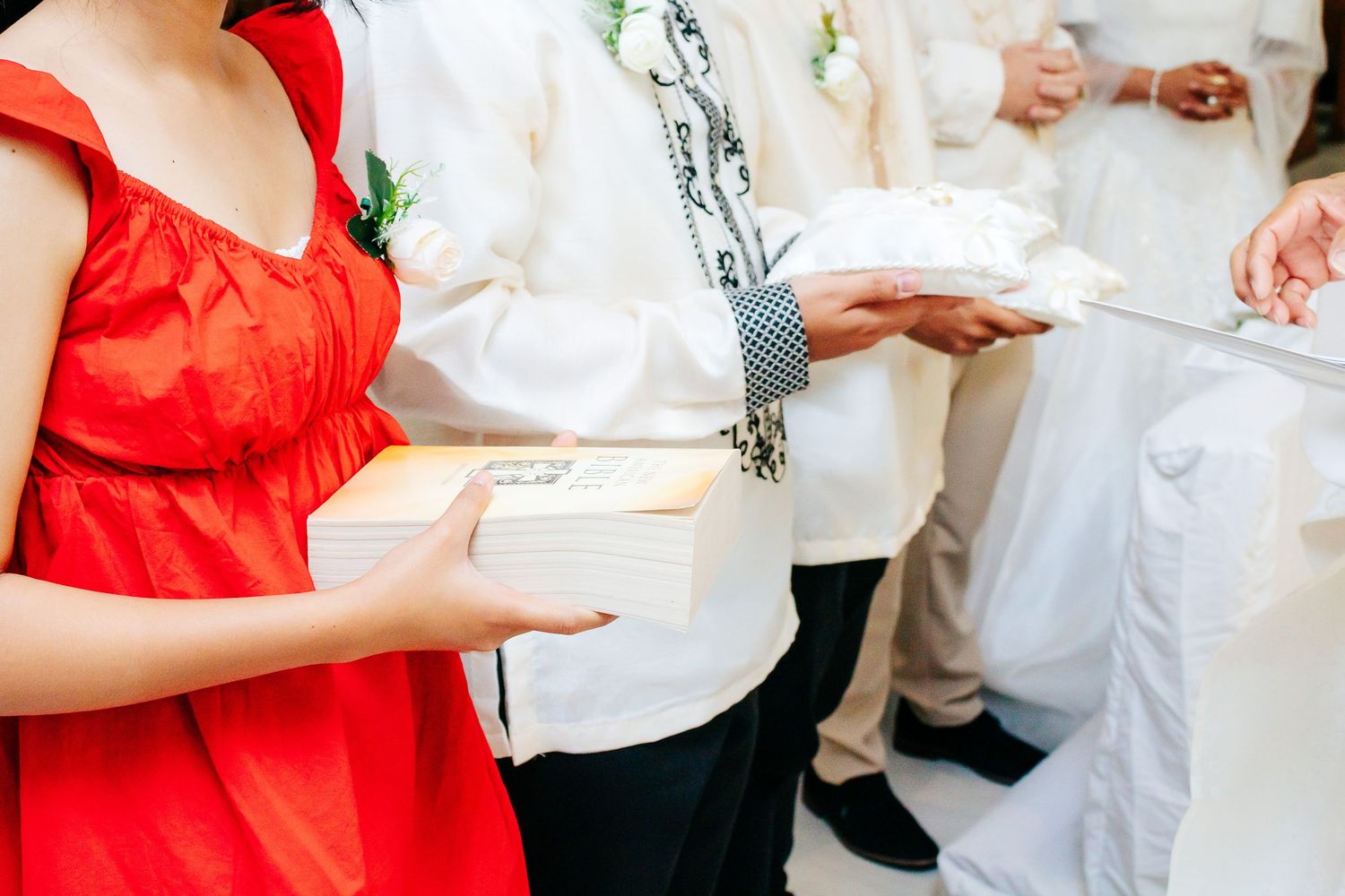 Wedding celebration dance sequence showing alternating black and red attire against white walls.