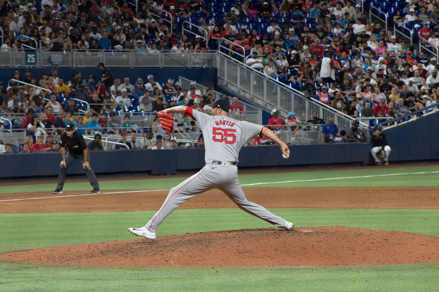 Pitcher wearing number 55 delivers pitch from mound during baseball game.
