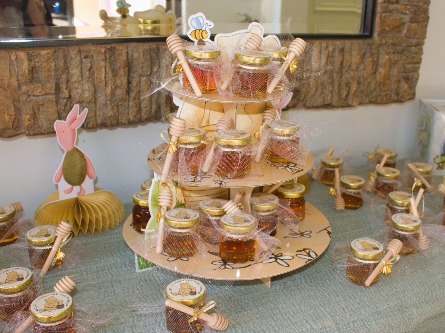 Winnie the Pooh themed party display with tiered honey pot treats and character decorations.