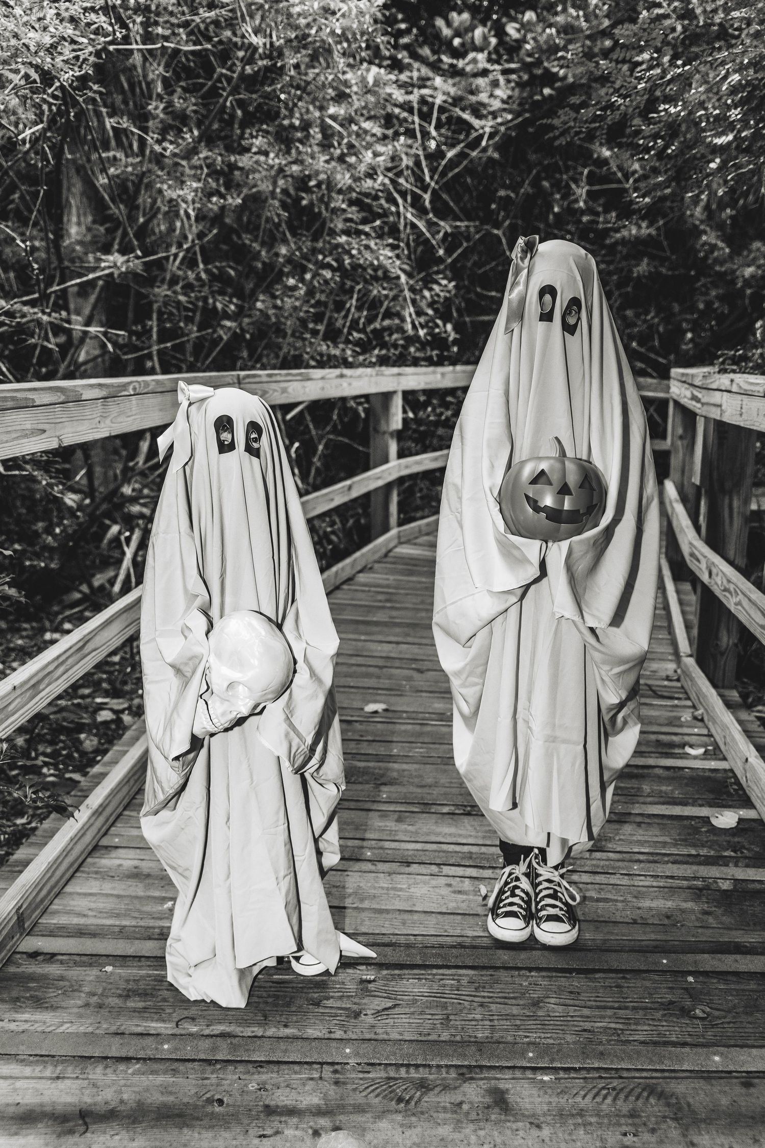 A sequence of ghost costume photos on a wooden boardwalk showing different spooky poses.