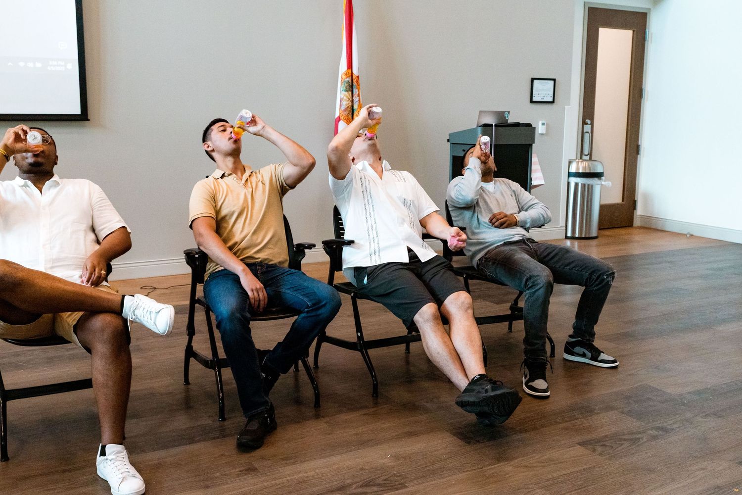 Guests playing a fun party game sitting in chairs at a baby shower celebration.