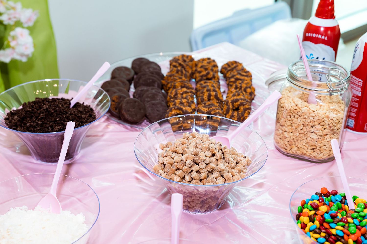 Pink and teal themed party table spread with cookies, candies and desserts for a baby shower celebration.