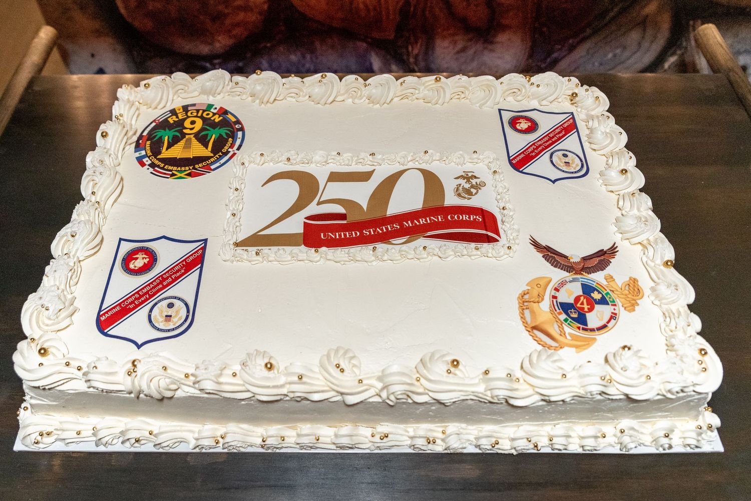 Decorated white sheet cake with military insignias and commemorative 250th anniversary design.