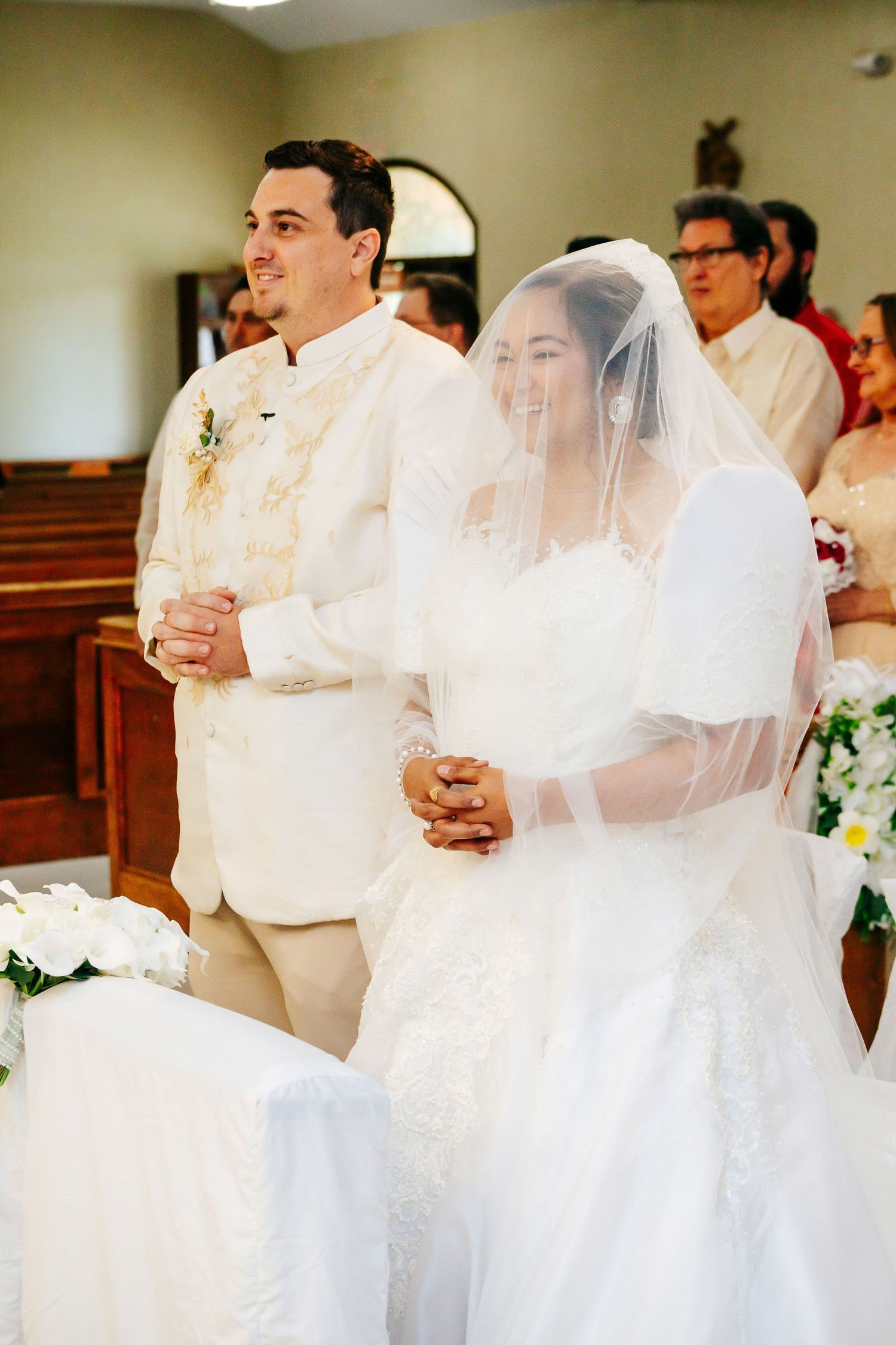 Wedding ceremony in progress showing participants in white attire.