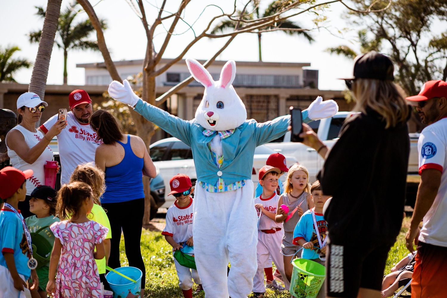 Easter bunny character interacts with a crowd of families during an outdoor spring celebration event.