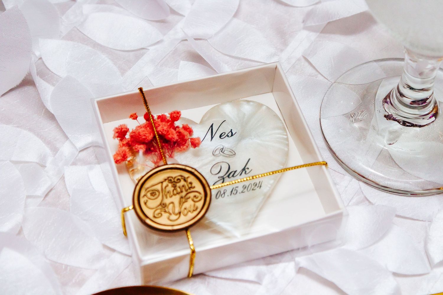 Wedding reception table details with wax seals and place cards in soft pink tones.