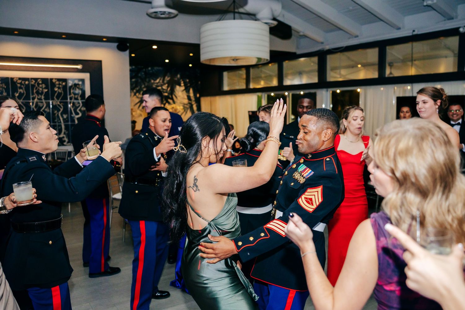 Couples dancing and celebrating on the dance floor at a formal military ball event.