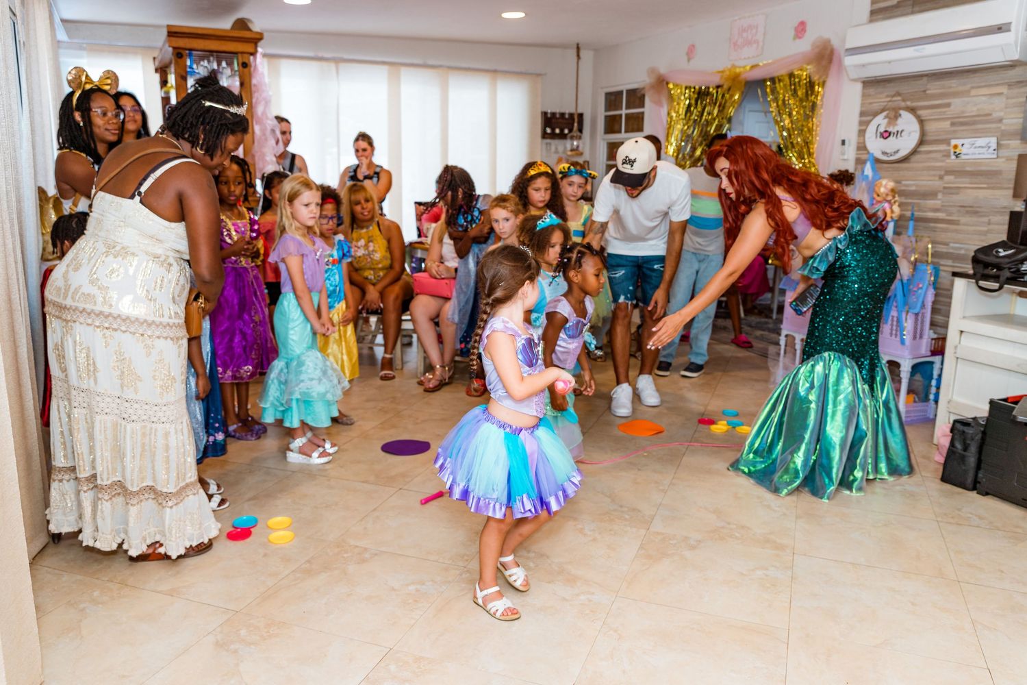 Children and adults dancing together at a colorful princess-themed birthday party.