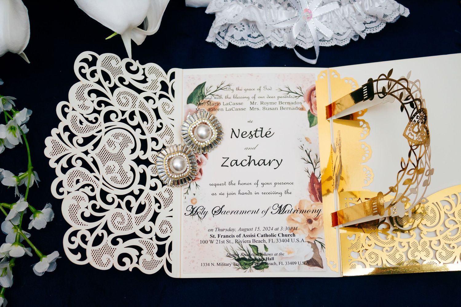 Elegant white laser-cut wedding invitations displayed in a row with floral designs and decorative paper details.
