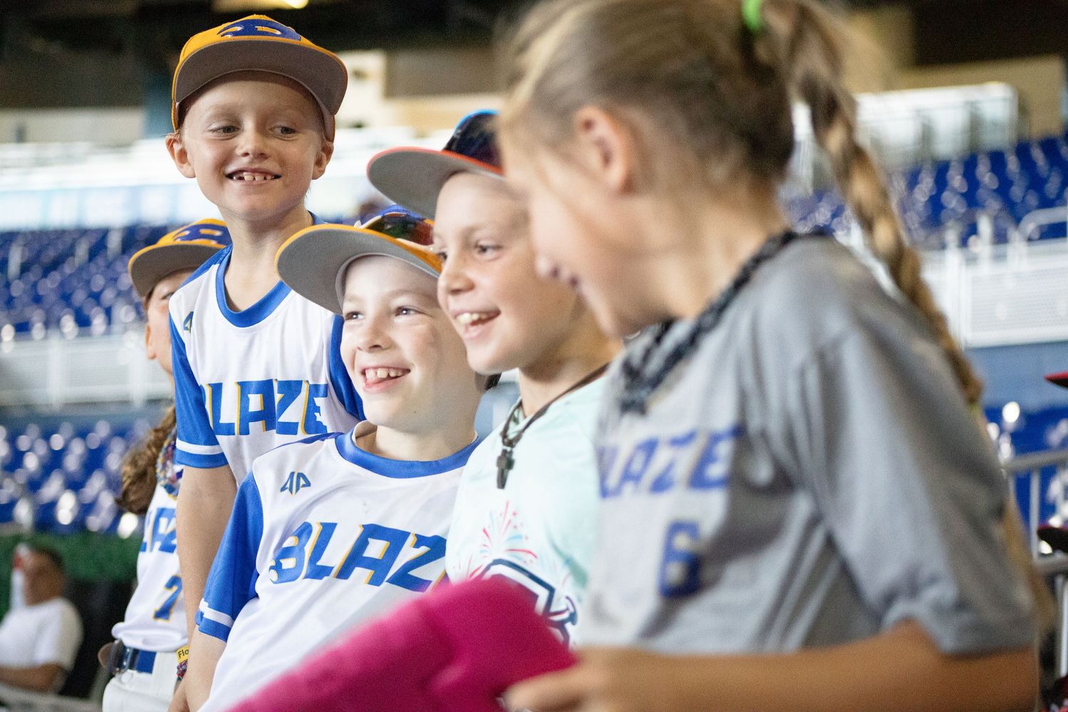 Young baseball fans gathered in stadium seats sharing excitement during game.