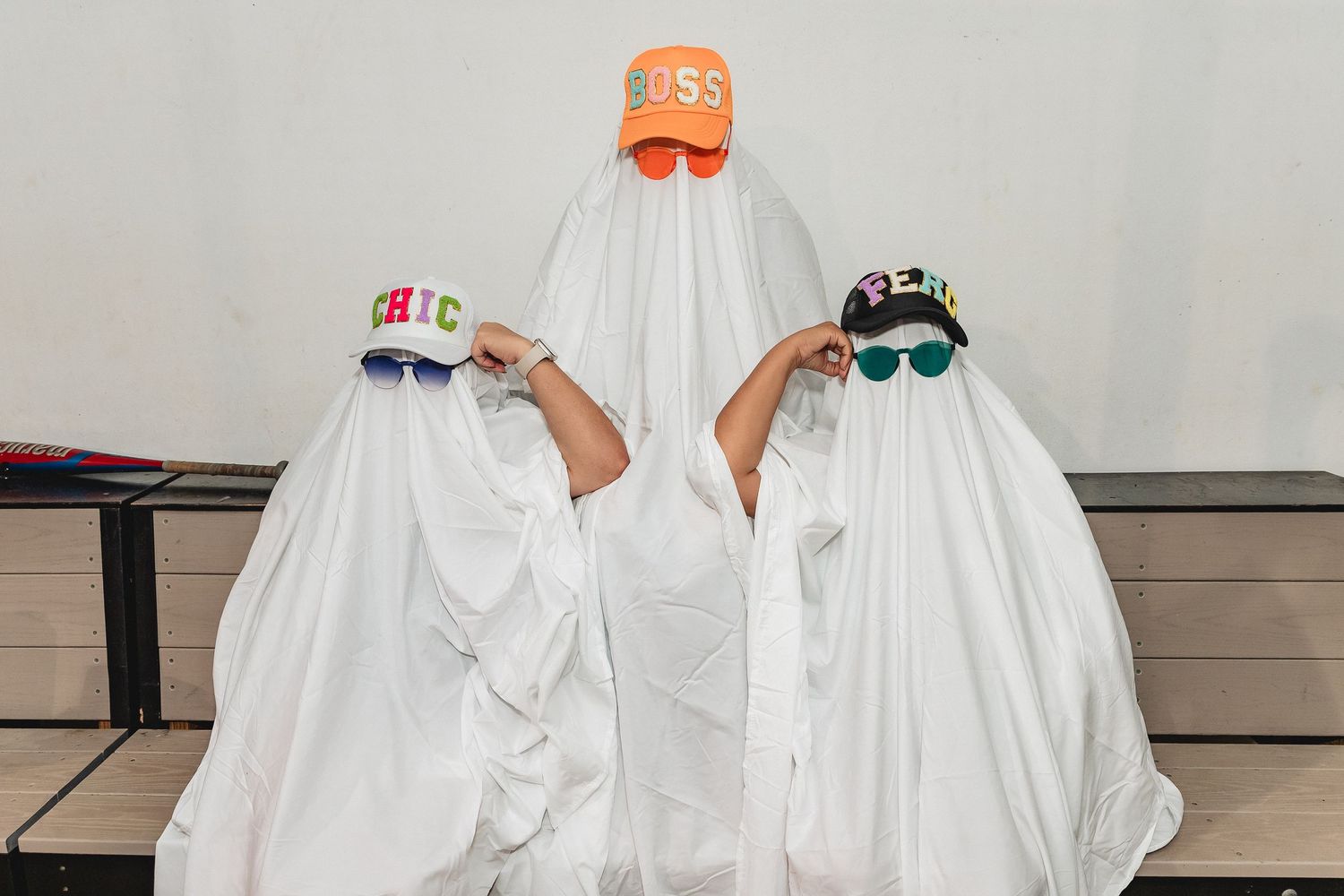 People in white ghost costumes and colorful hats stand together in formation.