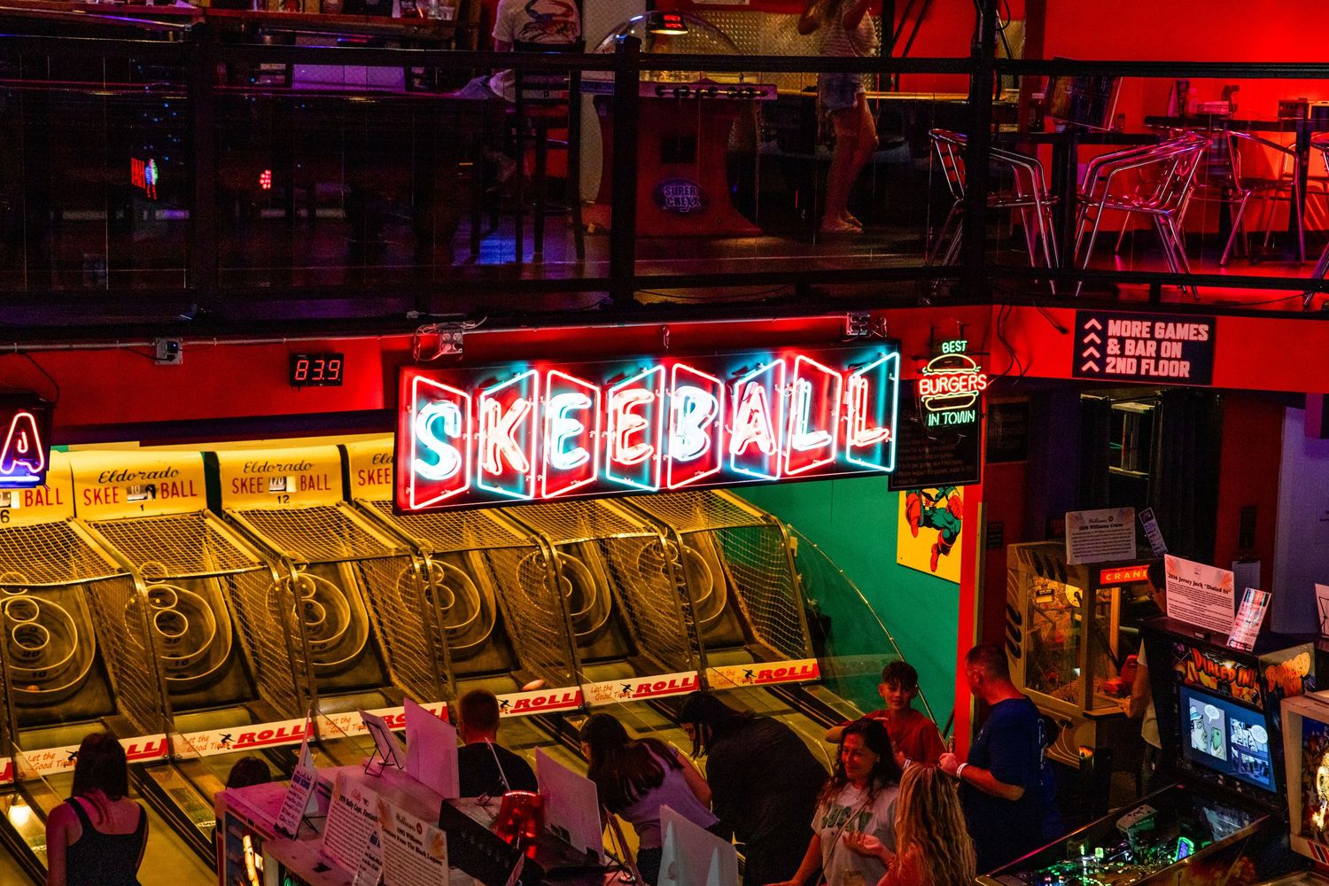 The image shows a neon sign for a game called 'Skee-ball' in a dimly lit arcade or entertainment venue.