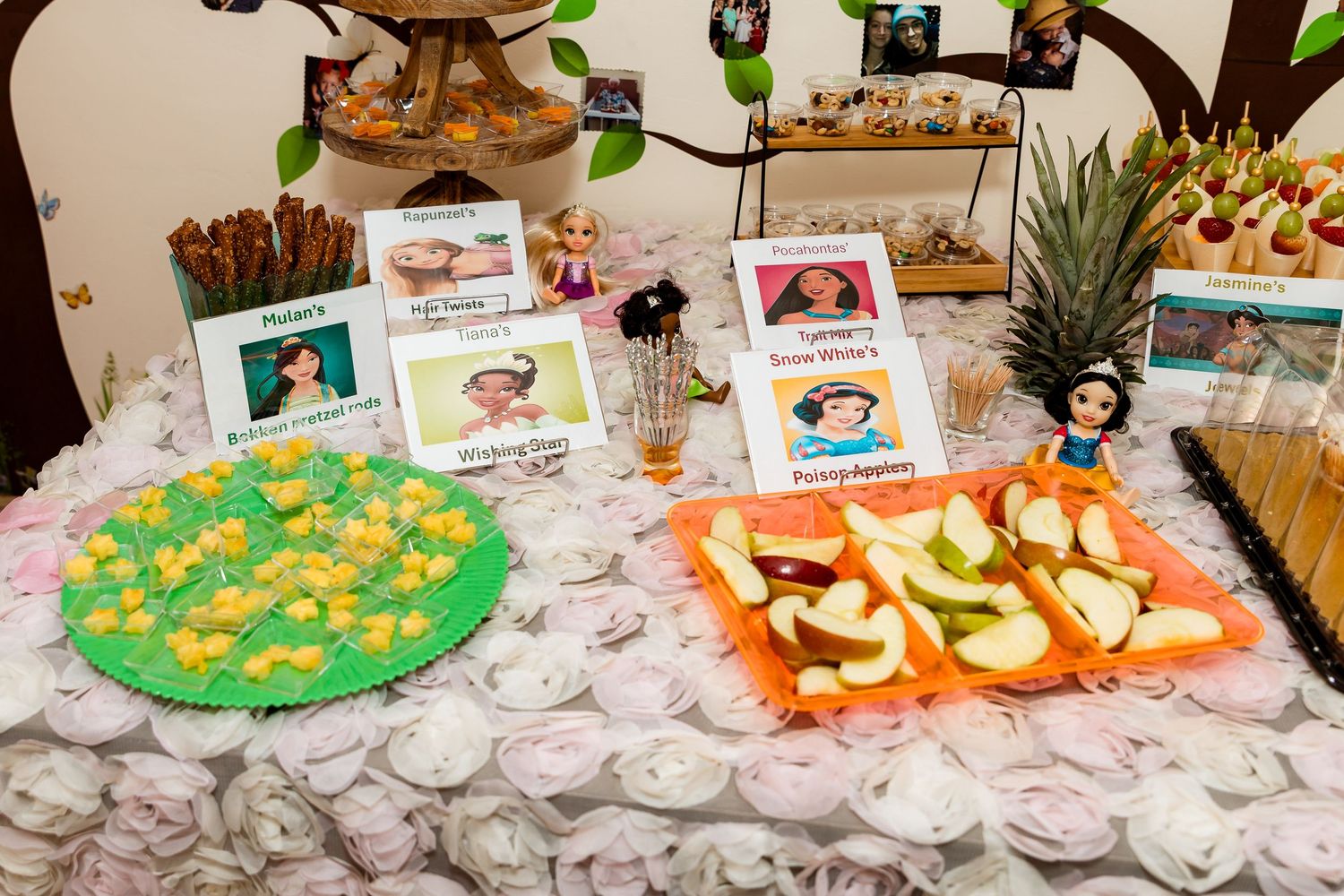 A party table decorated with themed treats and displays featuring colorful snacks and character-themed food cards.