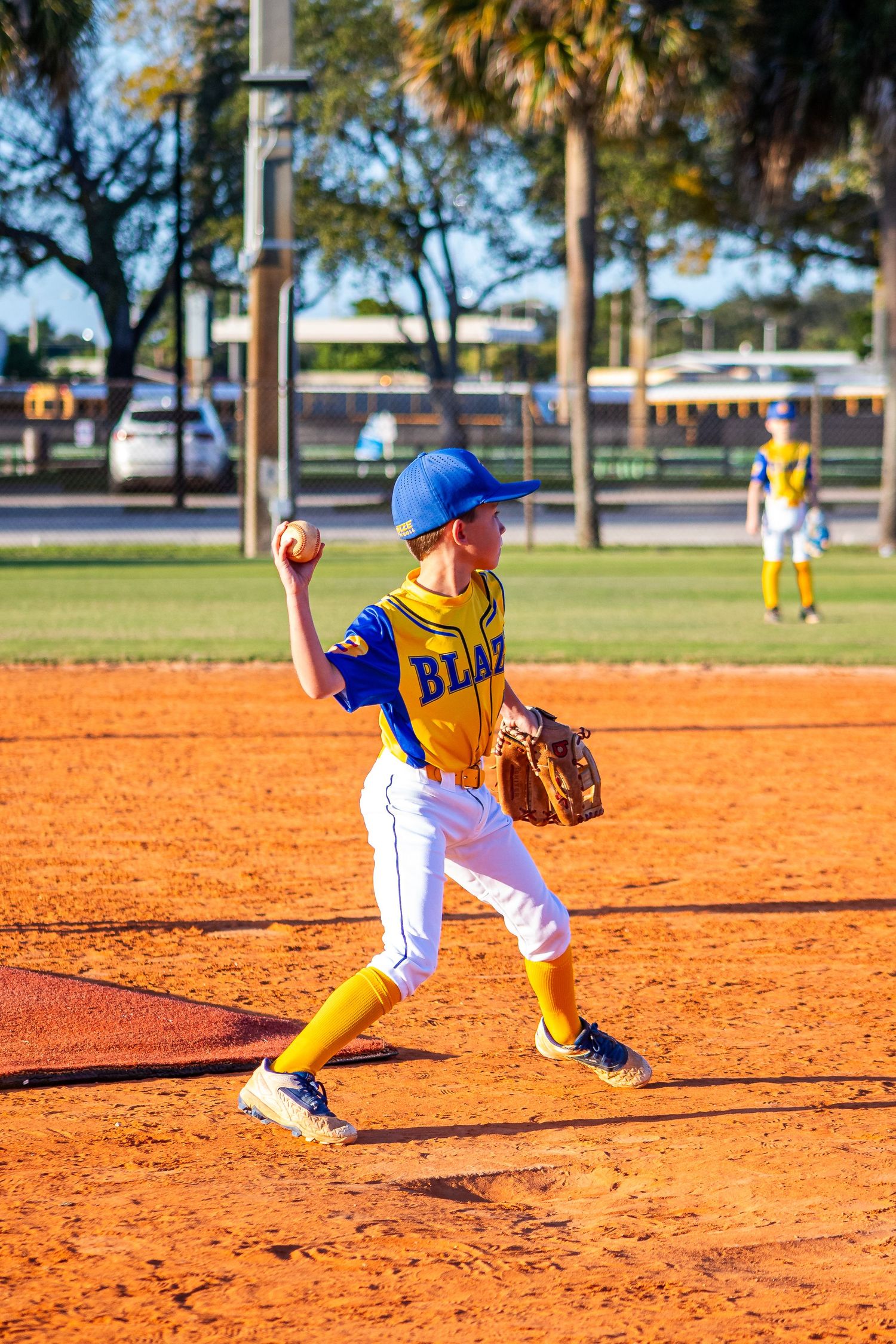 Baseball player fielding ground balls on orange clay infield during practice drills.