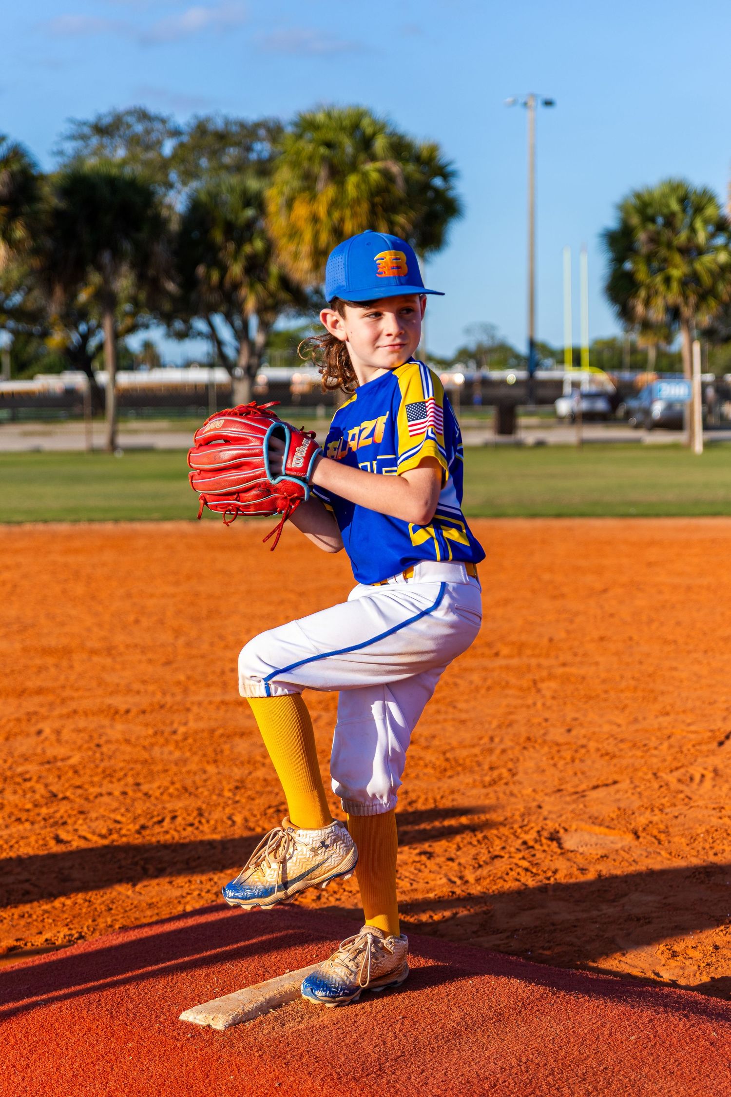 Baseball player demonstrating pitching form sequence on orange clay diamond with green field in background.