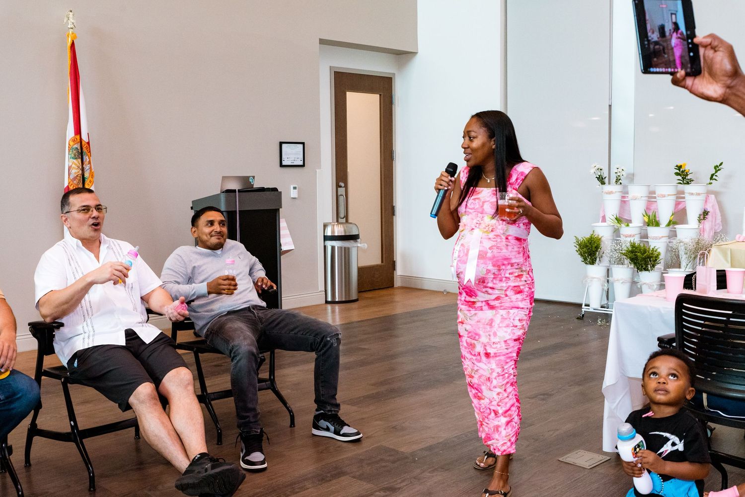 People casually interacting in a bright medical facility with pink decorative elements.