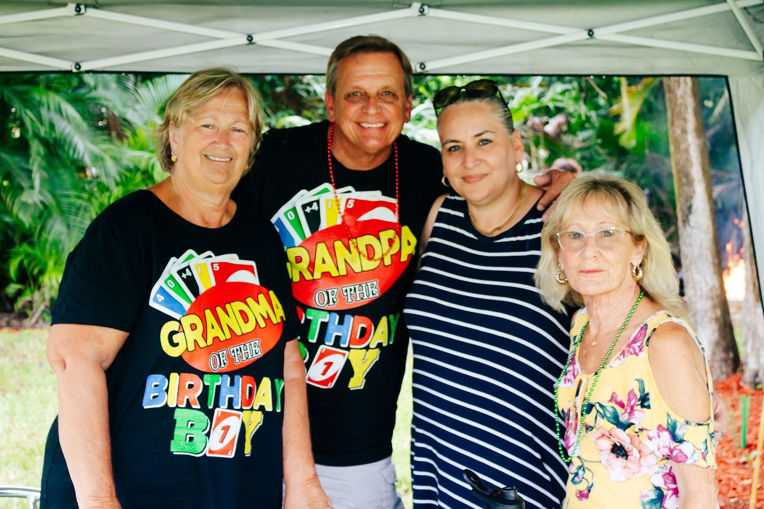 Outdoor party gathering with people in casual attire and celebratory t-shirts.