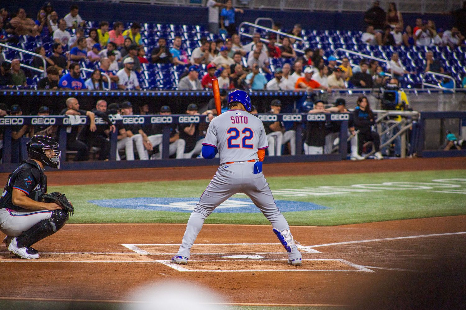 Baseball batter takes a swing at home plate during a night game at a professional baseball stadium.