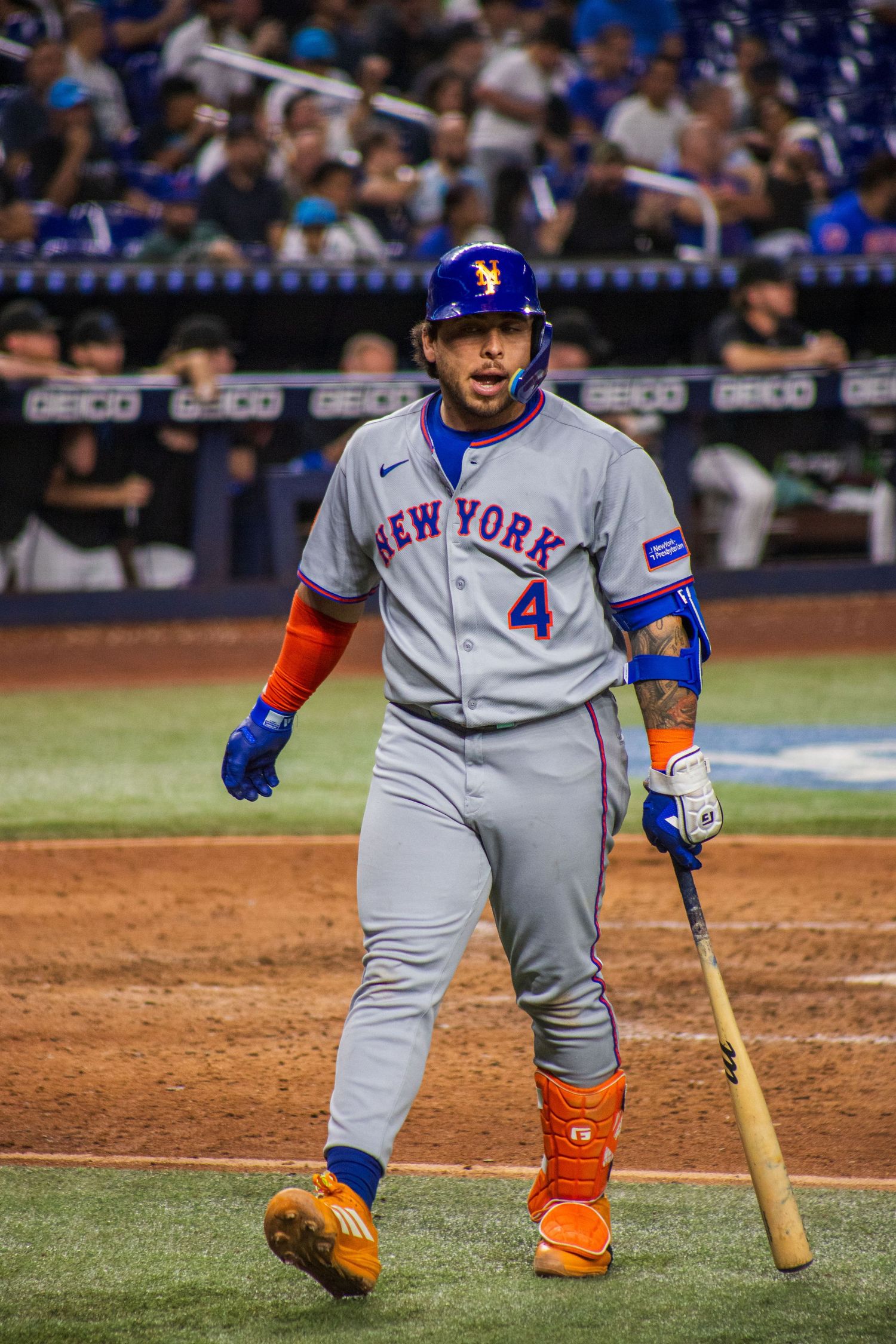 Baseball player in New York Mets uniform at bat during game.