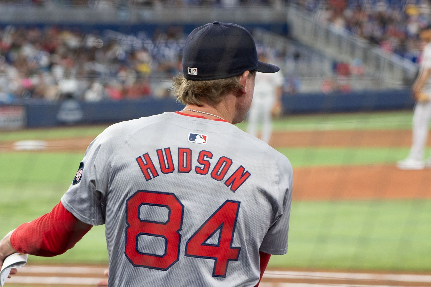 Hudson wearing jersey number 84 and Boston uniform stands on the baseball field.