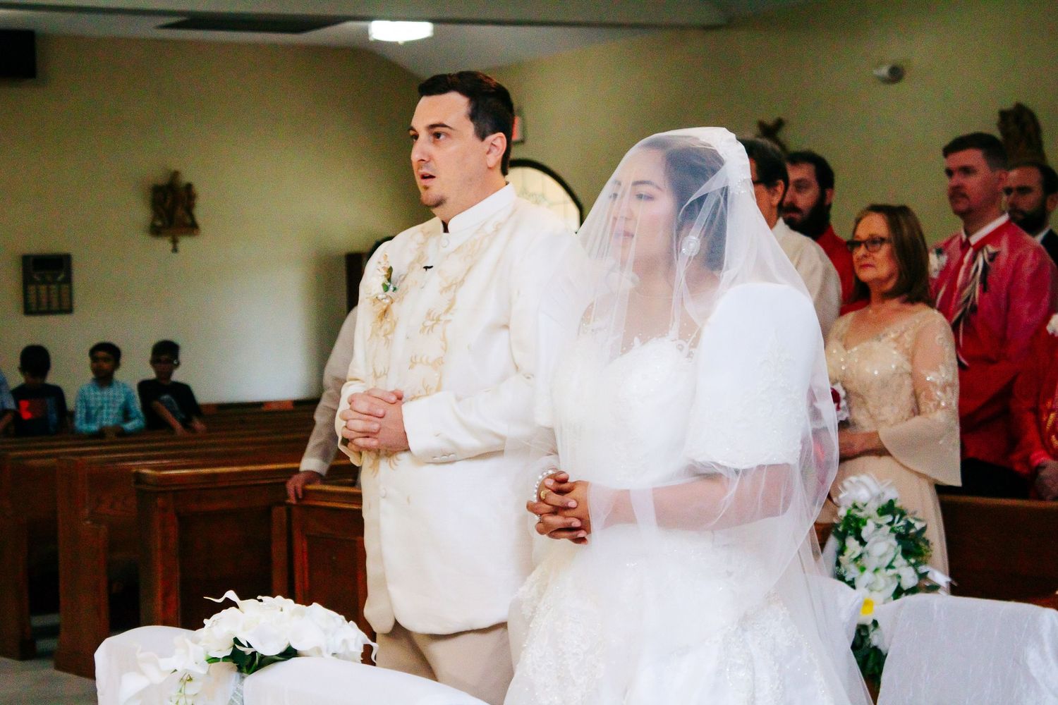 A close-up view of a wedding ceremony taking place inside a church with soft lighting and decor.