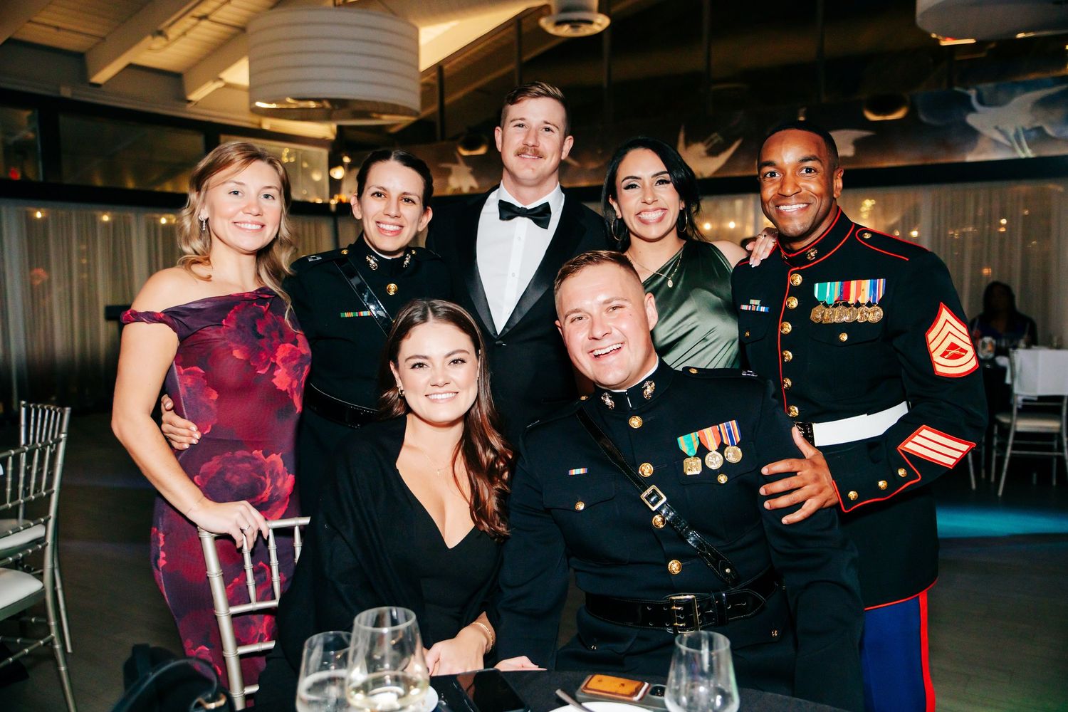 Guests enjoying a formal military event with Marines in dress uniforms at an indoor reception.