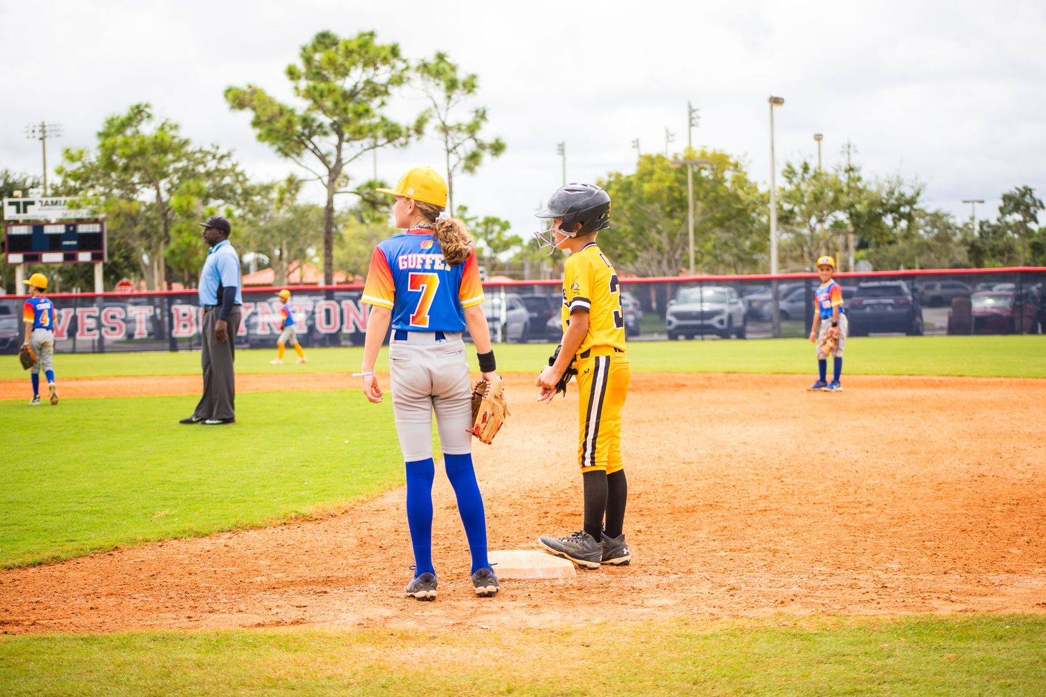 Players from opposing teams interact on baseball diamond during game.