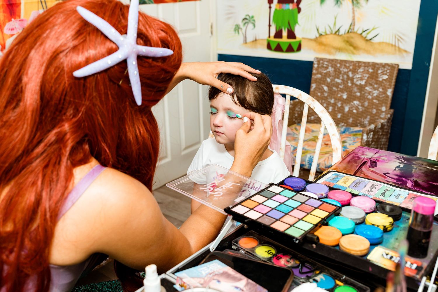 Colorful makeup palettes and cosmetic products spread out on a workspace during a beauty application session.